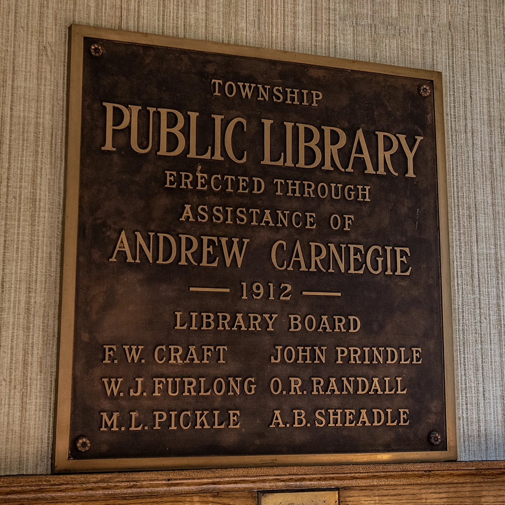 wall plaque showing original library board, the year it opened and that andrew carnegie donated ten thousand dollars to fund construction