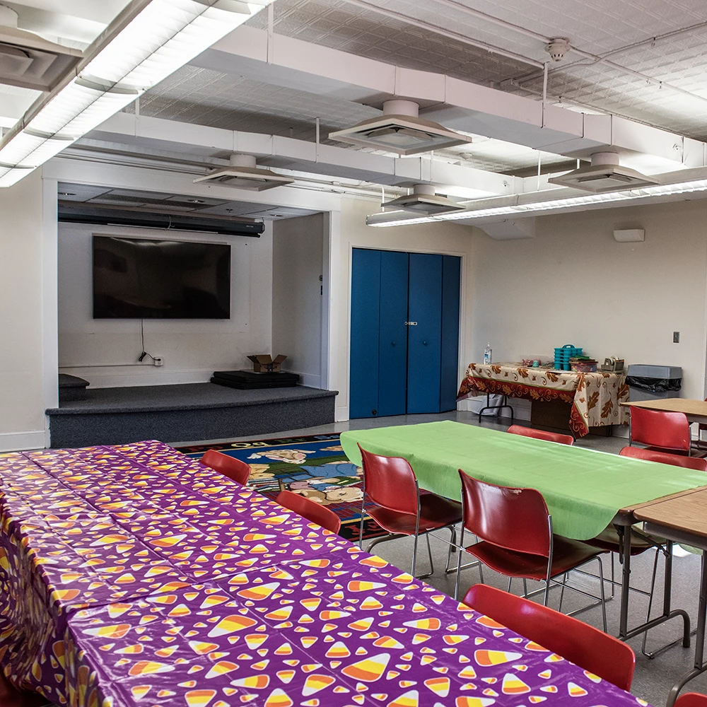 Meeting room at Flagg-Rochelle Public Library showing two long tables and chairs with a TV on the wall