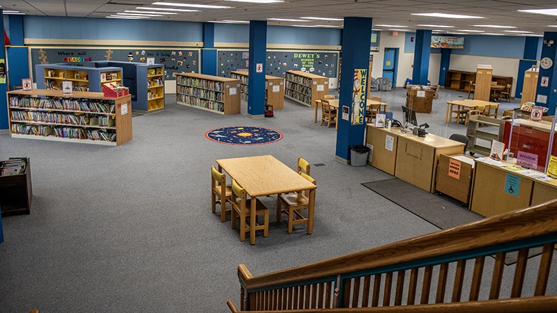 inside the Flagg-Rochelle Public Library that shows several tables and multiple book shelves full of books
