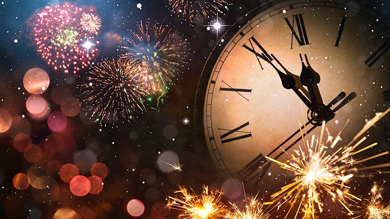 Fireworks and a clock indicating celebrating New Year's Eve